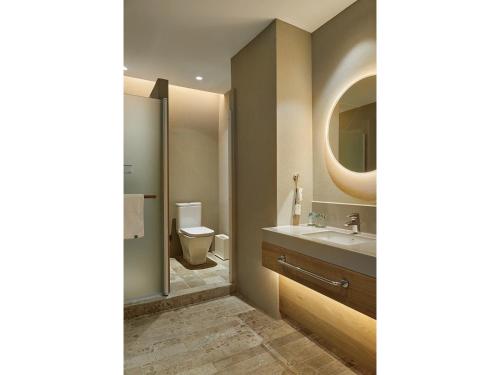 a bathroom with a sink and a toilet and a mirror at EBO Hotel Hangzhou Wulin - 5 mins drive to the West Lake in Hangzhou