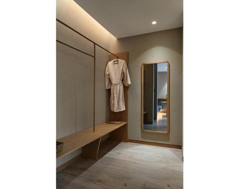 a dressing room with a mirror and a robe on a rack at EBO Hotel Hangzhou Wulin - 5 mins drive to the West Lake in Hangzhou