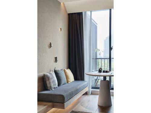 a living room with a couch and a window at EBO Hotel Hangzhou Wulin - 5 mins drive to the West Lake in Hangzhou