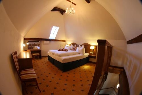 um quarto de hotel com uma cama e uma cadeira em Hotel Fortna em Chrudim