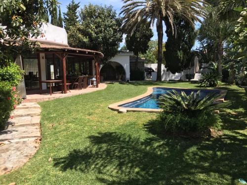 podwórko z basenem i domem w obiekcie Villa with Heated Pool and Jacuzzi close to Puerto Banus and Beach w mieście Estepona