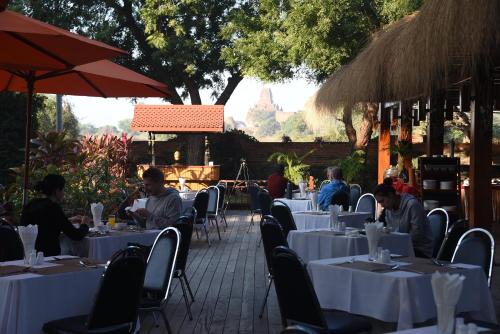 a group of people sitting at tables in a restaurant at The Hotel Umbra Bagan in Bagan