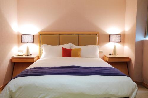 Una cama o camas en una habitación de 晶樺商務飯店 鄰近羅東車站