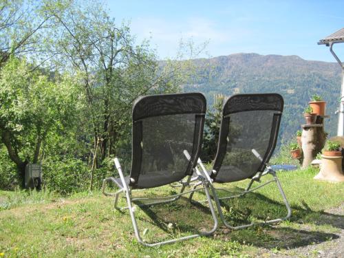 two black chairs sitting in the grass in a yard at Chalet Catton Two Bedroom Appartement near Bad Kleinkirchheim in Radenthein