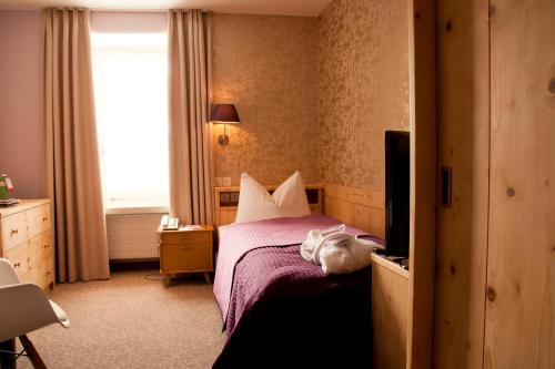 a hotel room with a bed and a television at Hotel Rosatsch in Pontresina