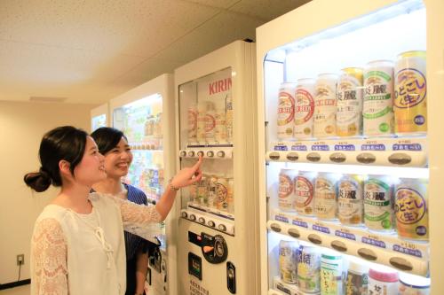 two women standing in front of an open refrigerator at Richmond Hotel Higashi Osaka in Osaka