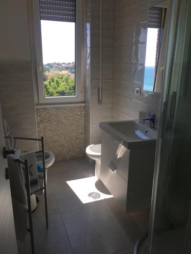 a bathroom with a sink and a toilet and a window at B&blu in Santa Marinella