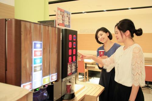 two women are looking at a display in a store at Richmond Hotel Higashi Osaka in Osaka