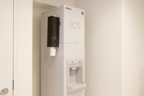 a white ice machine with a sign on a wall at Richmond Hotel Higashi Osaka in Osaka