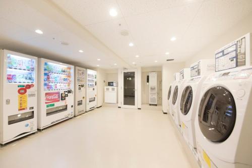 a laundry room with washing machines and machines at Richmond Hotel Higashi Osaka in Osaka