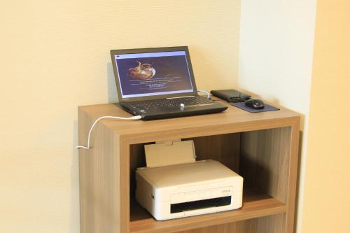 a laptop computer sitting on top of a computer printer at Richmond Hotel Higashi Osaka in Osaka