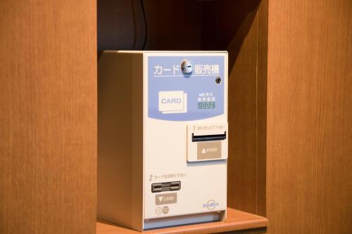 a machine sitting on a shelf next to a door at Richmond Hotel Higashi Osaka in Osaka