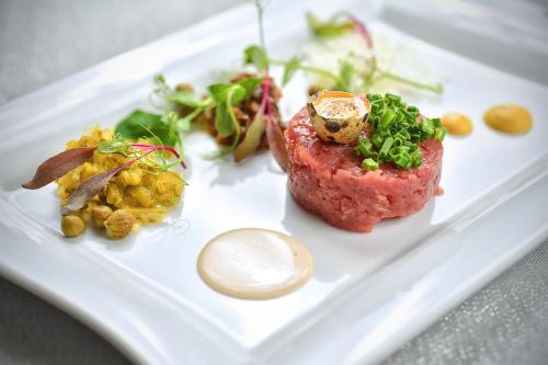 a white plate with a piece of meat and vegetables at Lubhotel in Lublin