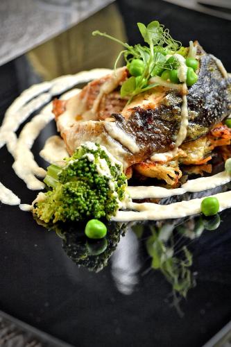 a plate of food with meat and broccoli on it at Lubhotel in Lublin