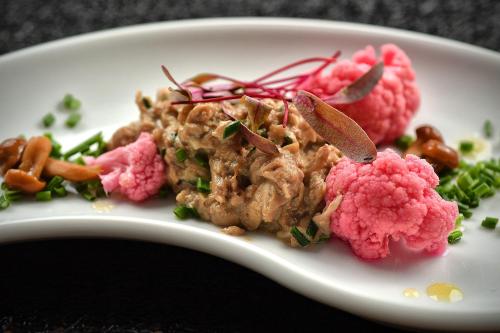 a plate of food with meat and pink cauliflower at Lubhotel in Lublin