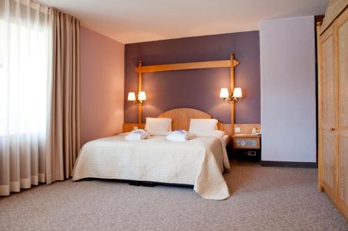 a bedroom with a bed with two towels on it at Hotel Rosatsch in Pontresina
