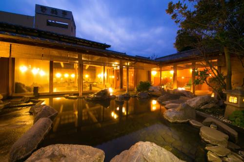 ein Gebäude mit einem Teich in der Nacht davor in der Unterkunft Yakakutei in Kirishima