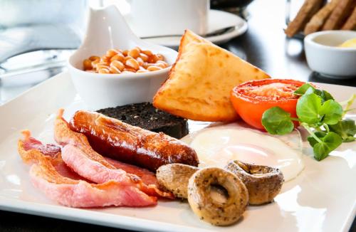 ラークホールにあるRadstone Hotelのベーコン、卵、トースト、豆が添えられた朝食のプレート