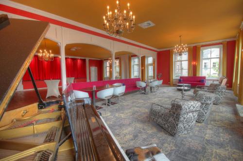 a large room with red walls and tables and chairs at Hotel In't Holt 1654 Grand Café & Logement in Zuidhorn