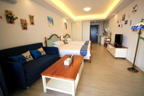 a living room with a bed and a couch at Coast-Inn Hailing Island in Yangjiang