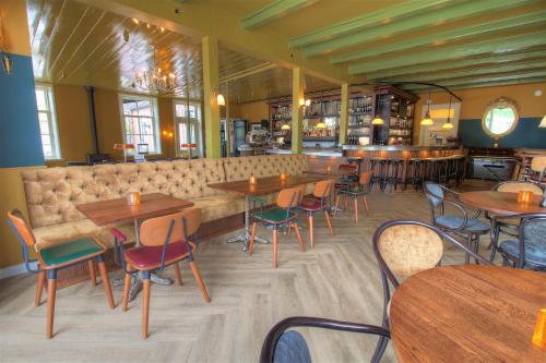 a restaurant with tables and chairs and a bar at Hotel In't Holt 1654 Grand Café & Logement in Zuidhorn