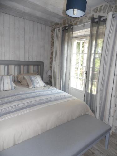 a bed in a room with a window and a bed sidx sidx at Gite STANDING climatisé avec piscine chauffée et SPA PRIVATIF in Alzonne