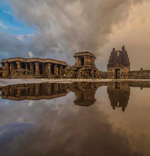 a reflection of a building in a body of water at Hotel Varsha Hampi in Hampi