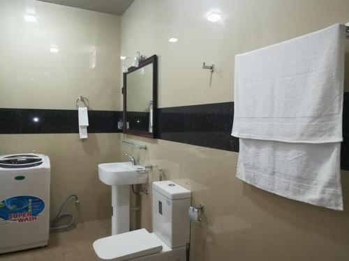 y baño con lavabo, aseo y espejo. en Thilini Hotel Apartment en Ratnapura