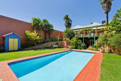 a swimming pool in front of a house at Corvah House in Castlemaine