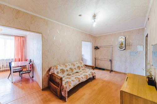 チタにあるDekabrist Apartment Shilova 46のベッド、テーブル、椅子が備わる客室です。