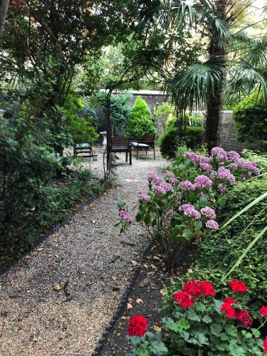 a garden with red and purple flowers and a bench at Jesmond Hotel in London