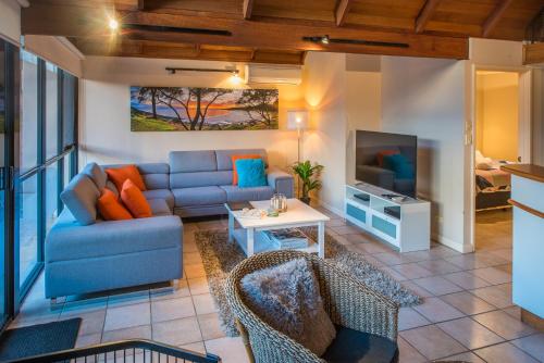 a living room with a couch and a tv at Whalers Cove Villas in Dunsborough