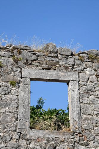 a window in a stone wall with a blue sky at Nadia's house in Pićan