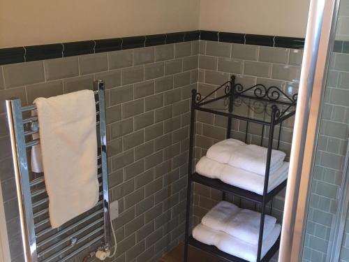 a bathroom with three towels and a shower at The Blackboys Inn in Framfield