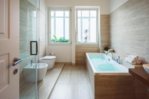 a bathroom with a tub and a toilet and a sink at Bluemoon Sardinia in Cagliari