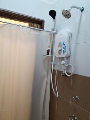 a shower in a bathroom with a shower curtain at The Sofea Inn Transit Room Airport Kota Bharu in Pengkalan Cepa