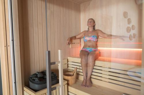 a woman is standing in a sauna at Forum Boutique Hotel & Spa - Adults Only in Alcudia