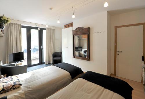 a hotel room with two beds and a mirror at aan de vaart in Mechelen