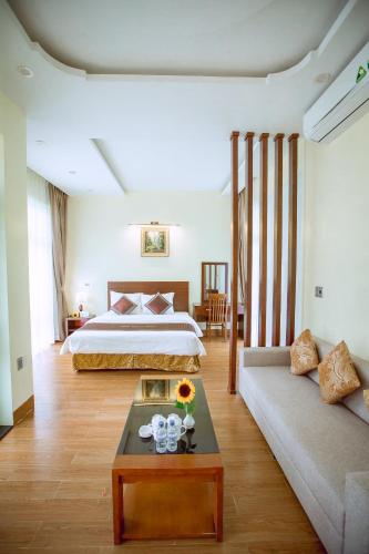 a hotel room with a bed and a couch at Thao Nguyen Hotel & Resort Moc Chau in Mộc Châu
