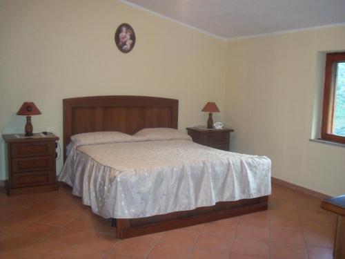 ein Schlafzimmer mit einem Bett und zwei Nachttischen mit Lampen in der Unterkunft La Tenuta B&B in Buonvicino