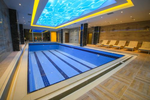 une piscine dans un hôtel avec une piscine intérieure dans l'établissement AYMİRA HOTEL & SPA, à Gereniz