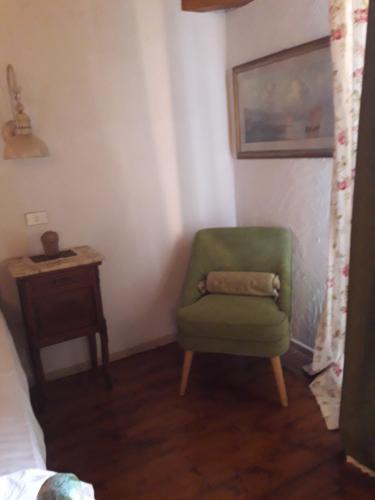 a green chair in a room with a table at Residenza Villa Spagnola in Parghelia