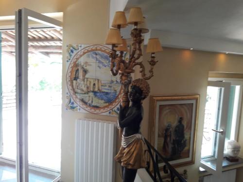 a statue of a woman hanging from a chandelier at Residenza Villa Spagnola in Parghelia