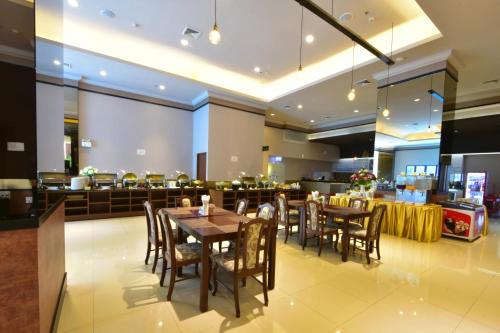 a dining room with tables and chairs in a restaurant at Siam Oriental Hotel in Hat Yai