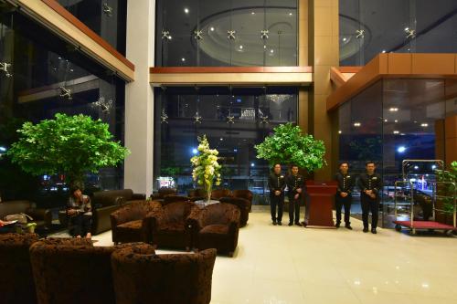 a group of men in uniform standing in a lobby at Siam Oriental Hotel in Hat Yai