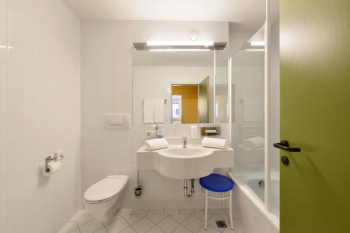 ein weißes Badezimmer mit Waschbecken und Toilette in der Unterkunft Hotel Neutor Express in Salzburg