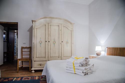a bedroom with a large whiteoire with towels on a bed at Country Relais La Torretta Baronale in San Giorgio Montagna