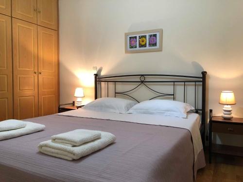 a bedroom with a large bed with towels on it at Leonidio Climb2red home in Leonidion