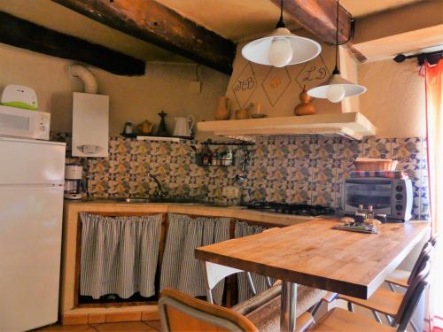 a kitchen with a wooden table and a refrigerator at Casa Zambrana in Pinofranqueado