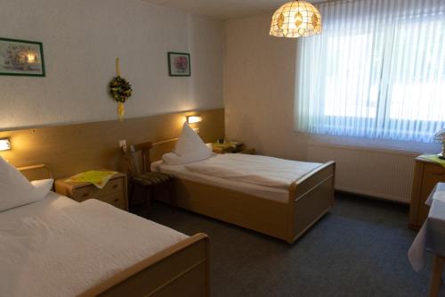 a hotel room with two beds and a window at Haus Kanne in Bad Driburg